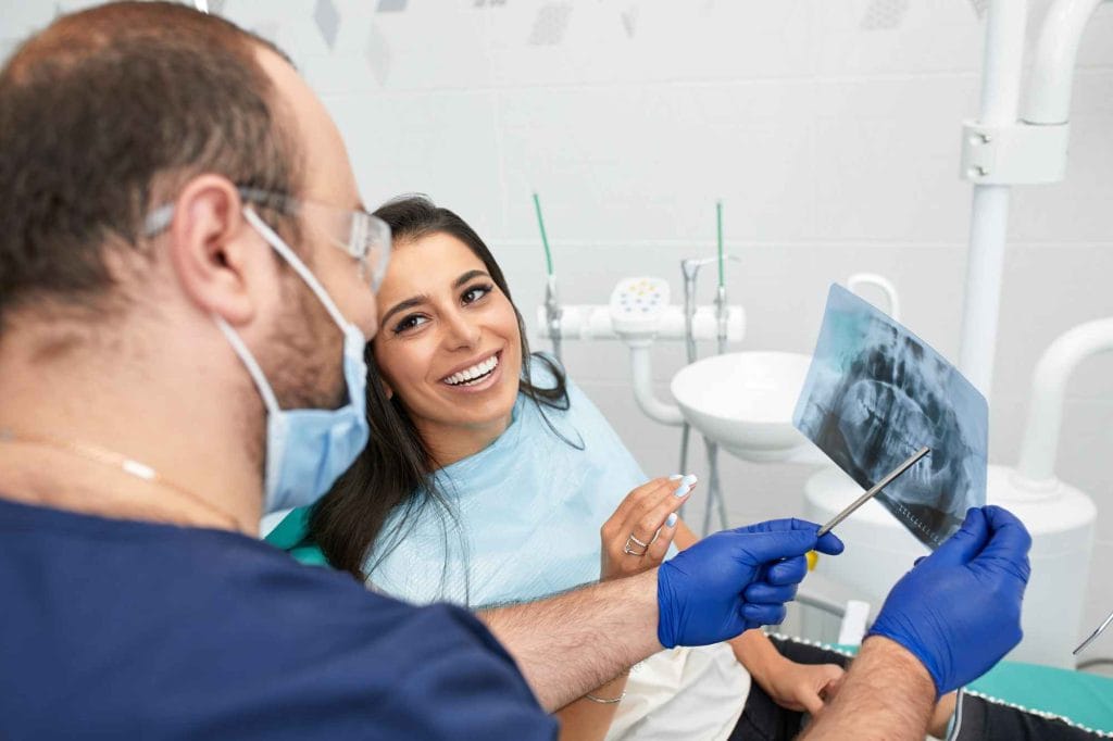 dentist showing the x-ray of teeth to the patient